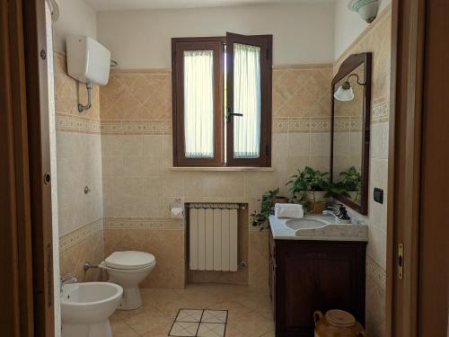 a bathroom with a toilet and a sink and a mirror at Casa Santa Iaca in Vitigliano