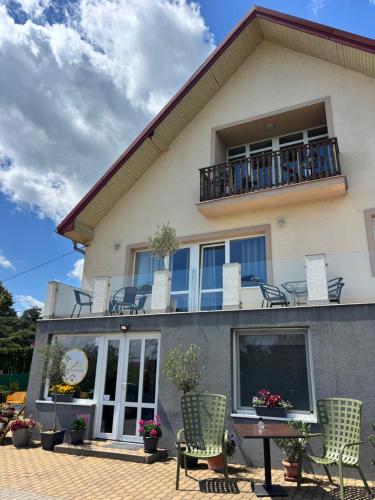 a large house with chairs and a balcony at Balkonett Vendégház in Balatonfüred
