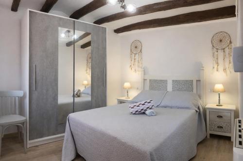 a bedroom with a large bed and a mirror at Cal Folquer in Alentorn