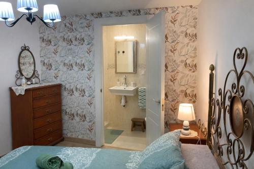 a bedroom with a bed and a sink and a mirror at Cal Folquer in Alentorn