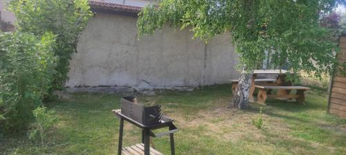 a backyard with a table and a bench and a tree at Petit studio charmant in Lezoux