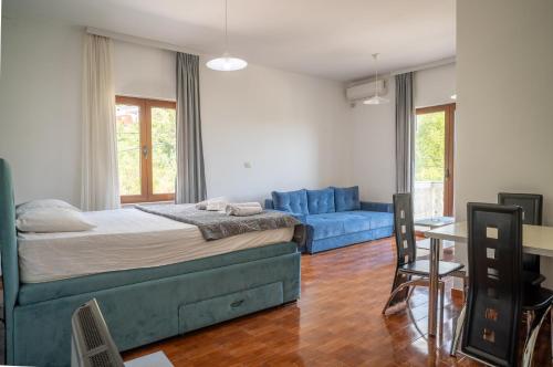 a bedroom with a blue bed and a blue couch at Apartments Oasis in Budva