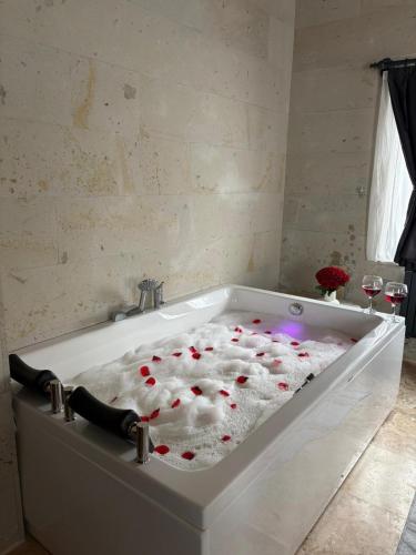 a bath tub filled with red hearts in a bathroom at Duruer Living Home in Ürgüp