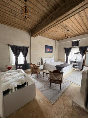a large bedroom with two beds and a tub at Duruer Living Home in Ürgüp