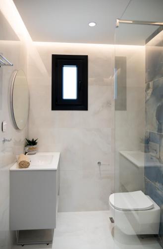 a bathroom with a toilet and a sink and a shower at Villa Rinoula-private pool in Vitalades