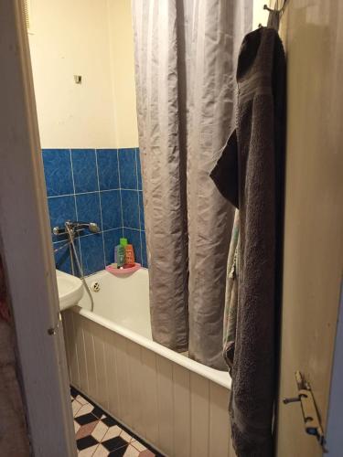 a bathroom with a tub and a sink and a shower curtain at Квартира над Парусом in Zhmerynka