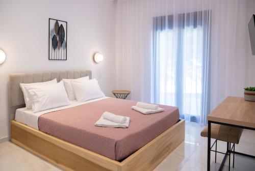 a bedroom with a bed with two towels on it at Villa Rinoula-private pool in Vitalades