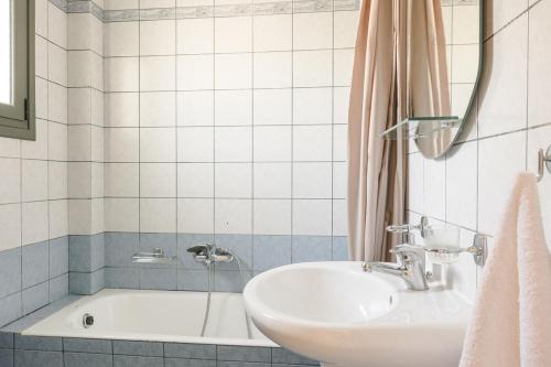 a bathroom with a sink and a bath tub at Villa Dora in Kefallonia