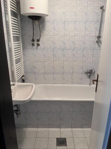 a bathroom with a white tub and a sink at Nedzarici sobe in Sarajevo