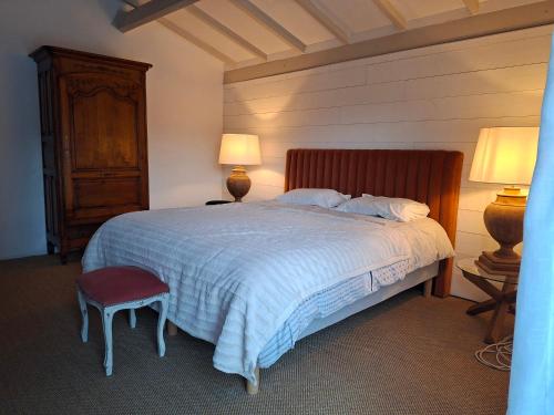 a bedroom with a bed with two lamps and a chair at Casa Oksana in Castelnau-de-Montratier