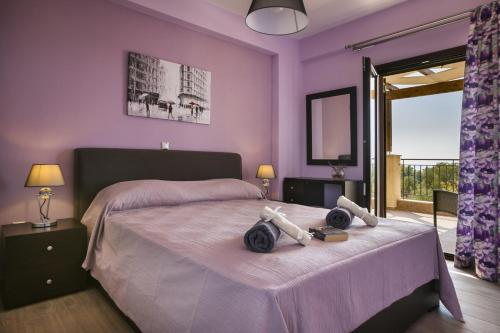 a bedroom with a large bed with purple walls at Villa Karavias by Villa Select in Trapezaki