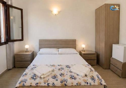 a bedroom with a large bed with two night stands at Albergo Villamarina in Santa Teresa Gallura