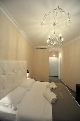 a bedroom with a large white bed with a chandelier at Villa Zaccardi in Rome