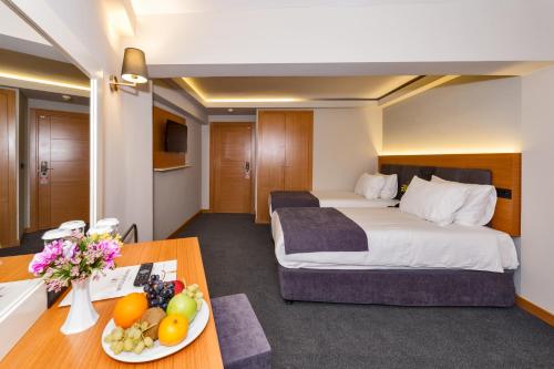 a hotel room with a bed and a table with a plate of fruit at Bergama Hotel in Istanbul