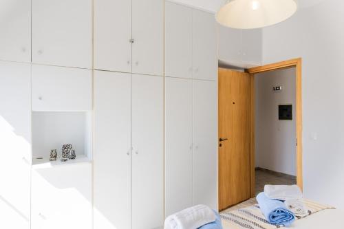 a room with white walls and a hallway with a mirror at PhώS Casa Lachania in Lachania