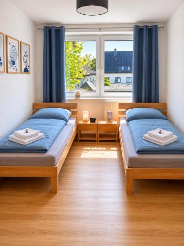 a bedroom with two beds and a window at FeWo Auszeit eigene große Terrasse mit Strandkorb und Grill in Wesel