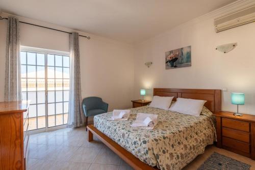 a bedroom with a bed and a large window at Villa Fatima by Villa Select in Galé