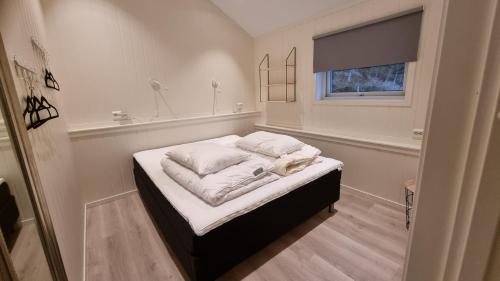 a small bedroom with a bed with pillows on it at Brudevoll Gard in Ørsta
