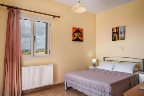a bedroom with a bed and a window at Athina Rose in Trapezaki