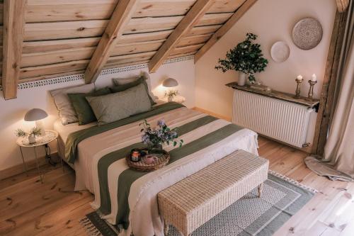 a bedroom with a large bed in a attic at Tajna Bazia in Nidzica