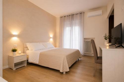 a bedroom with a bed and a desk and a television at IL CENTRO rooms in Cerignola