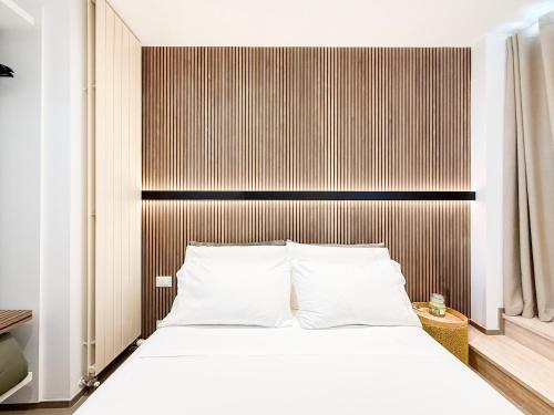 a bedroom with a white bed with a wooden headboard at Sky Garden - luxury suite in Monopoli