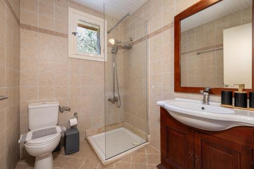 a bathroom with a toilet and a sink and a shower at Villa Helona in Keri
