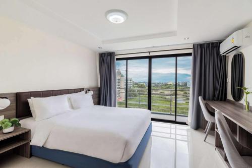 a hotel room with a bed and a large window at The Grand Palm Villa in Ban Bang Phrao