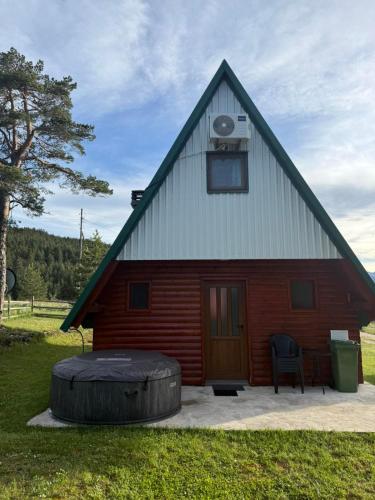 a barn with a large tire in front of it at Zabljak_vikendica in Žabljak