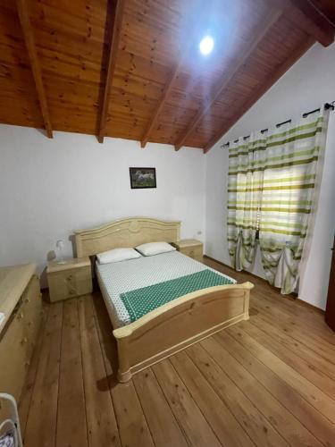 a bedroom with a bed and a wooden floor at Sinan moraci in Dukat