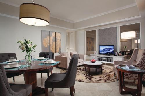 a living room with a couch and a table and a television at Ascott Jakarta in Jakarta