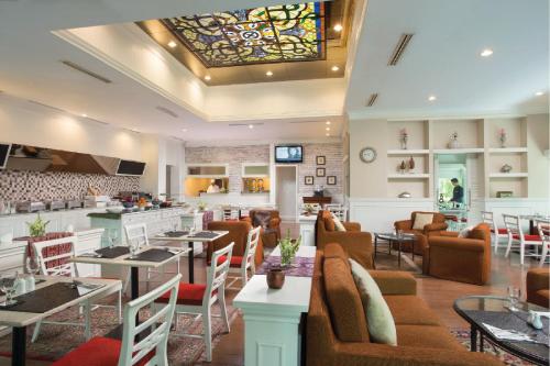 a restaurant with tables and chairs and a bar at Ascott Jakarta in Jakarta