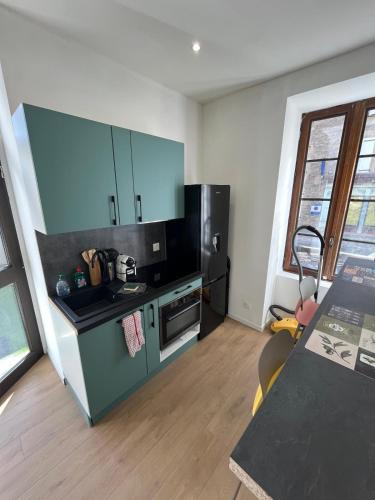 a kitchen with blue cabinets and a counter top at L'Echappée Verte Climatisée in Marvejols