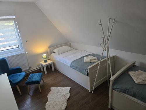 a small bedroom with a bed and a chair at Ferienhaus am Bethlehem Kanal in Papenburg