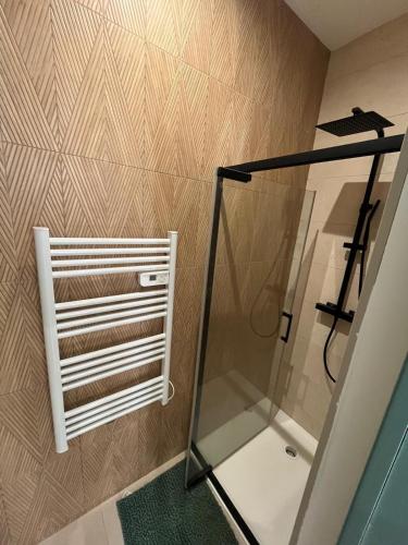 a bathroom with a shower and a towel rack at L'Echappée Verte Climatisée in Marvejols