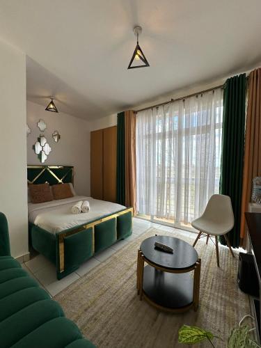 a bedroom with a bed and a couch and a table at Luxe Haven in Nairobi