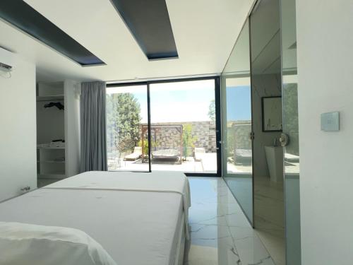 a bedroom with a white bed and a large window at Private Pool House for 6 by Olivujoj in Anavyssos