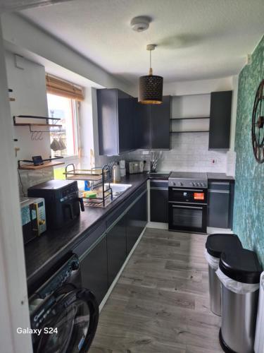 a kitchen with black cabinets and a counter top at Millers Ben Nevis View in Caol