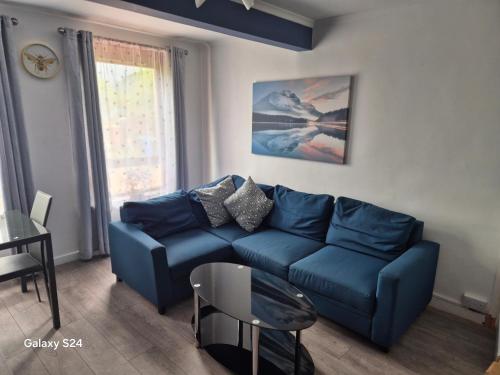 a living room with a blue couch and a table at Millers Ben Nevis View in Caol