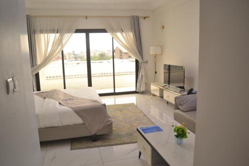 a bedroom with a bed and a living room at jPALACE in Bonamoussadi