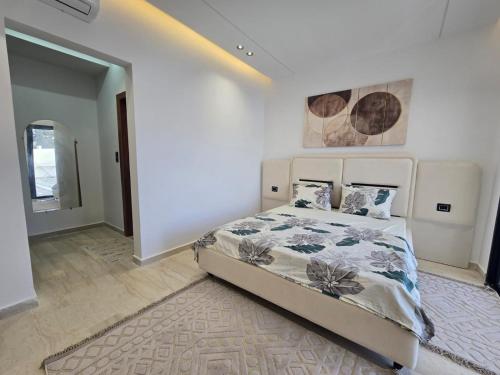 a bedroom with a bed and a painting on the wall at Dar Aalya in Djerba