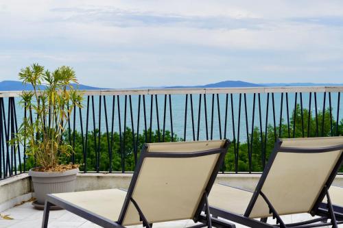 two chairs sitting on a balcony overlooking the water at Marina Sarafovo by Cosher in Burgas