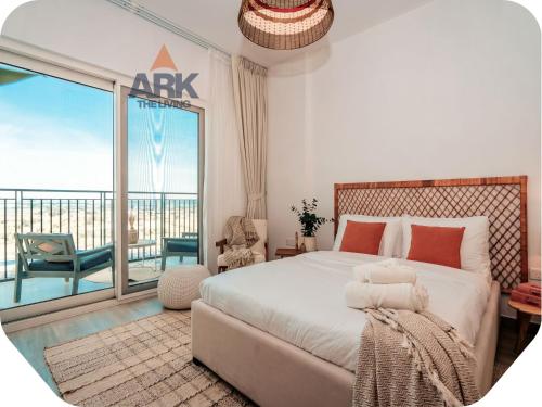 a bedroom with a large bed and a balcony at Ark Living Stay in Yas Island in Yas Island