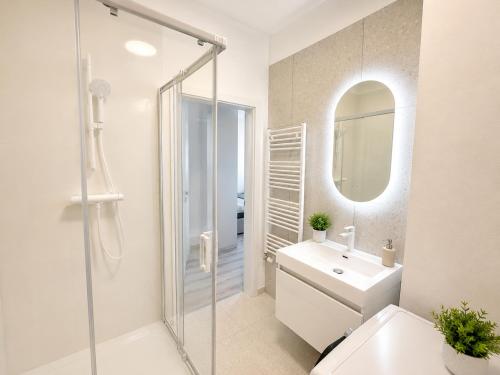 a bathroom with a shower and a sink and a mirror at Luxury White Residence in Trenčín