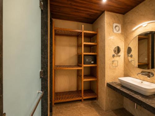 a bathroom with a sink and a mirror at The himalayan chester in Manāli