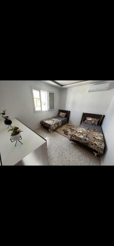 a living room with two beds and a table at Villa baya in Djerba