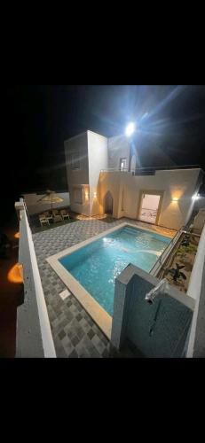 a large swimming pool at night with a light on it at Villa baya in Djerba