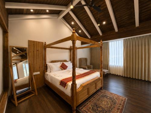 a bedroom with a four poster bed and a mirror at The himalayan chester in Manāli