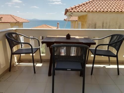 a table and chairs on a balcony with a view of the ocean at La petite maison in Xiropigado