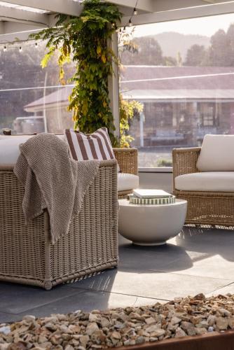 a patio with wicker chairs and a bowl on a patio at Amadiya Port Arthur Villas in Port Arthur